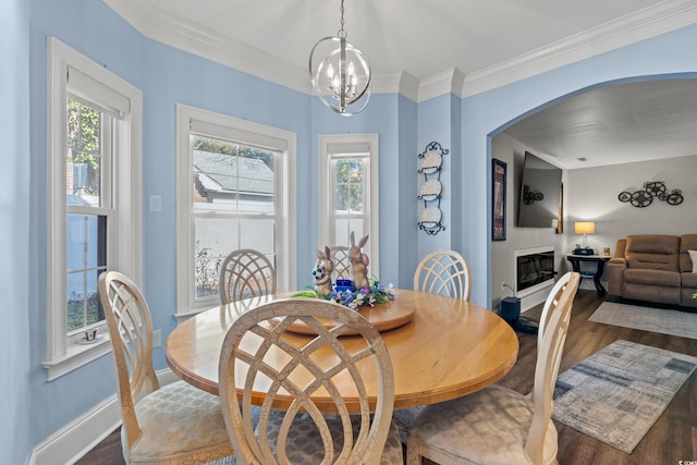 dining room with arched walkways, plenty of natural light, wood finished floors, and an inviting chandelier