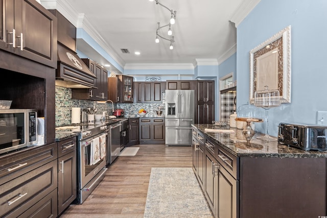 kitchen with appliances with stainless steel finishes, visible vents, decorative backsplash, and dark brown cabinets