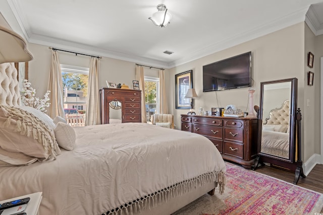 bedroom with baseboards, visible vents, ornamental molding, and wood finished floors