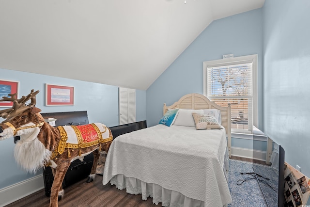 bedroom with lofted ceiling, baseboards, and wood finished floors