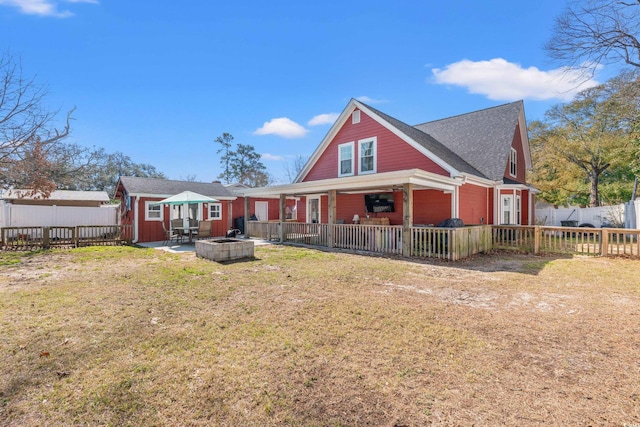 back of property featuring fence private yard, a patio area, a lawn, and an outdoor fire pit