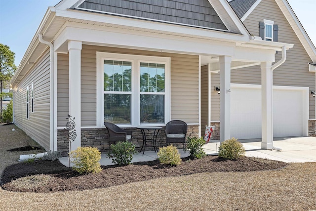 view of front of property with stone siding, covered porch, and concrete driveway