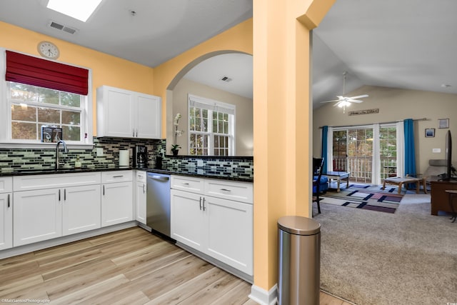 kitchen featuring a sink, visible vents, white cabinetry, open floor plan, and decorative backsplash