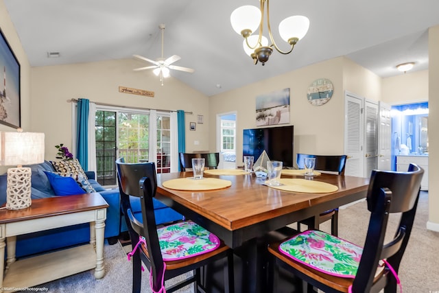 carpeted dining area featuring visible vents, vaulted ceiling, and ceiling fan with notable chandelier