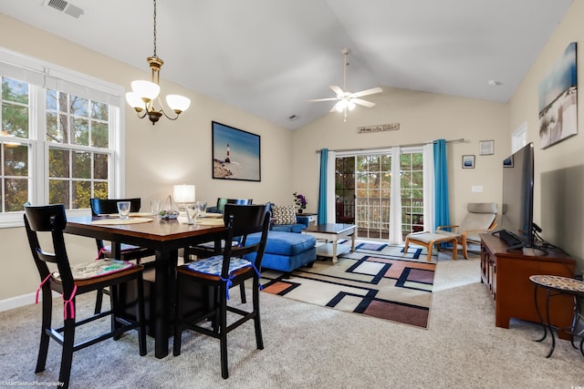 carpeted dining room with visible vents, vaulted ceiling, baseboards, and ceiling fan with notable chandelier