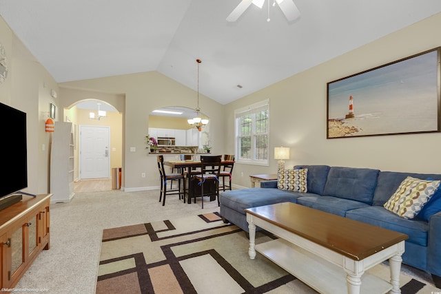 living area featuring arched walkways, carpet, lofted ceiling, baseboards, and ceiling fan with notable chandelier