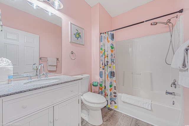 bathroom featuring toilet, shower / bath combo, wood finished floors, and vanity