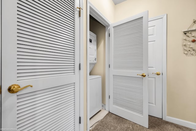 washroom with laundry area, baseboards, stacked washer / drying machine, and light colored carpet