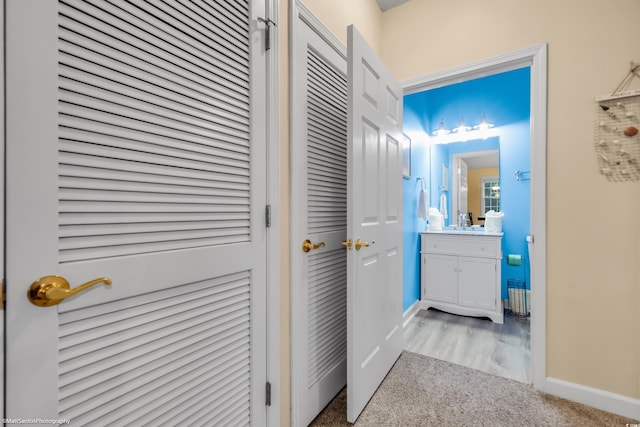 hall featuring a sink and baseboards