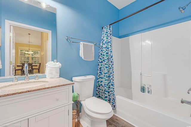 full bath featuring vanity, wood finished floors, shower / bath combo with shower curtain, and toilet