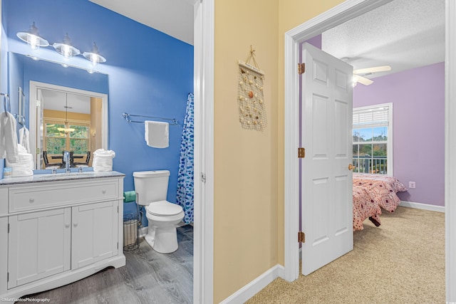 full bath featuring baseboards, vanity, toilet, and a healthy amount of sunlight