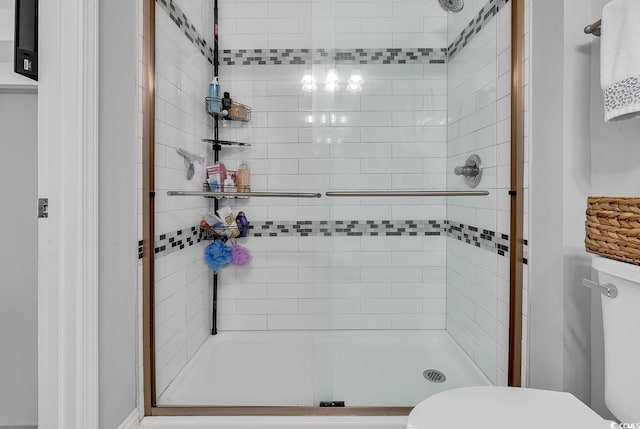 bathroom featuring a shower stall and toilet