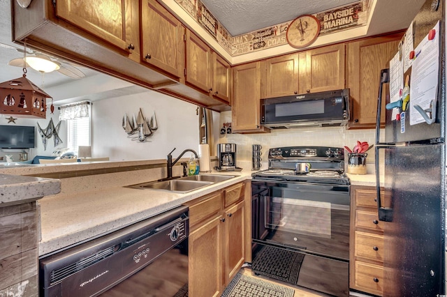 kitchen featuring brown cabinets, light countertops, decorative backsplash, a sink, and black appliances