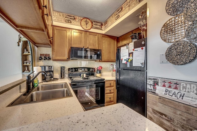 kitchen with light countertops, brown cabinetry, a sink, a textured ceiling, and black appliances