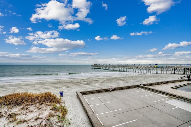 property view of water featuring a pier and a view of the beach