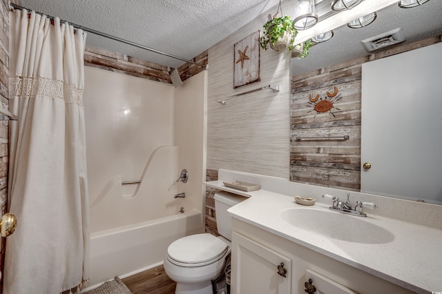 full bathroom featuring a textured ceiling, wooden walls, vanity, visible vents, and shower / bath combo with shower curtain