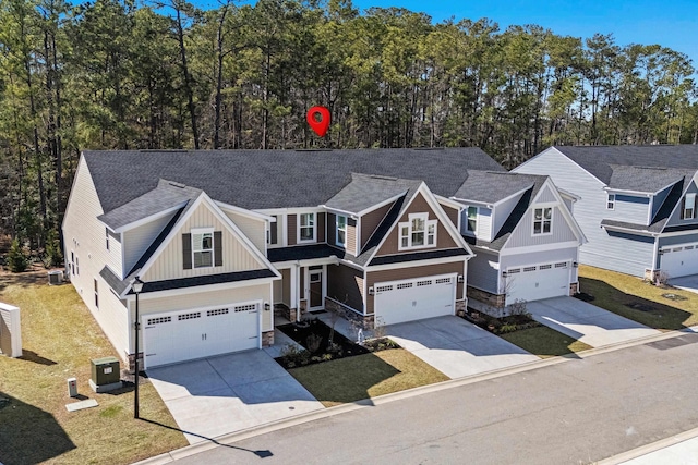 view of front of property featuring concrete driveway, stone siding, and an attached garage