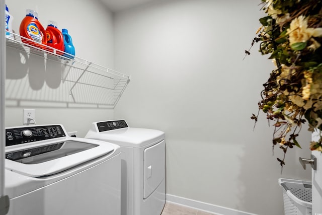 laundry room with laundry area, washer and clothes dryer, and baseboards