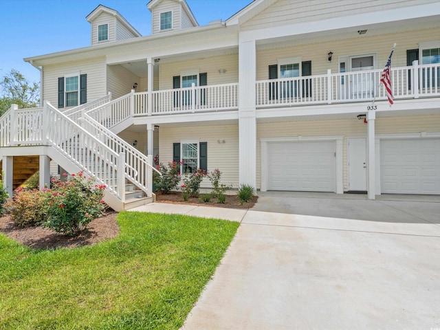 view of front facade featuring driveway, covered porch, stairs, and a garage