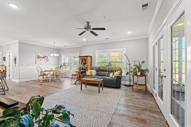 living room with recessed lighting, ceiling fan with notable chandelier, wood finished floors, visible vents, and ornamental molding