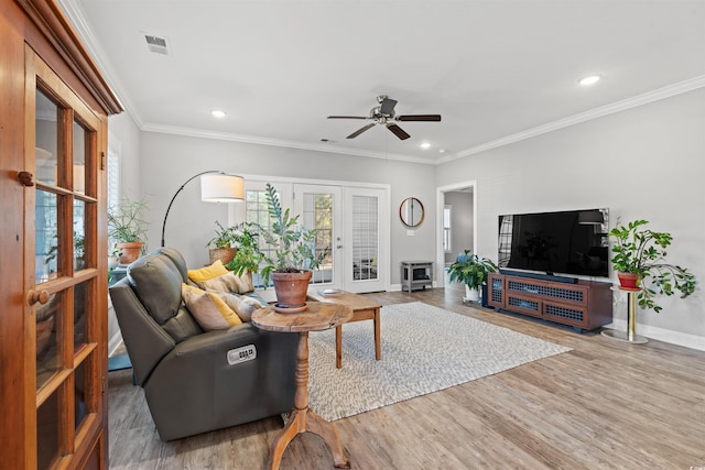 living area with french doors, visible vents, baseboards, and wood finished floors