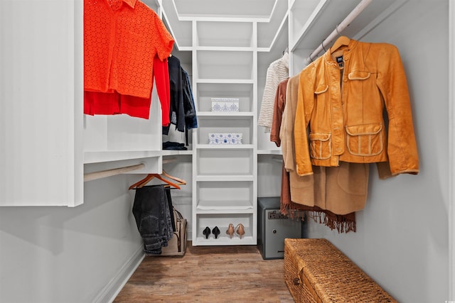 walk in closet with wood finished floors