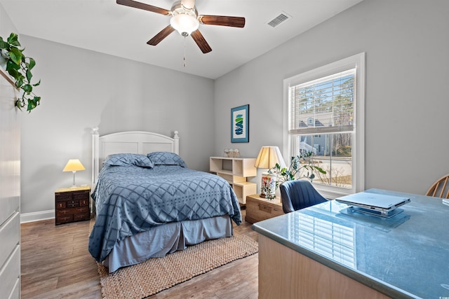 bedroom featuring light wood finished floors, baseboards, visible vents, and a ceiling fan