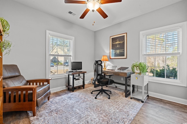 office with a healthy amount of sunlight, visible vents, baseboards, and wood finished floors