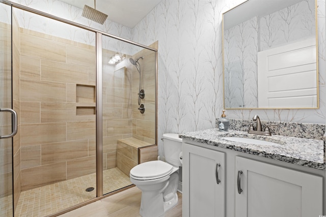 full bath with toilet, wallpapered walls, a shower stall, and vanity