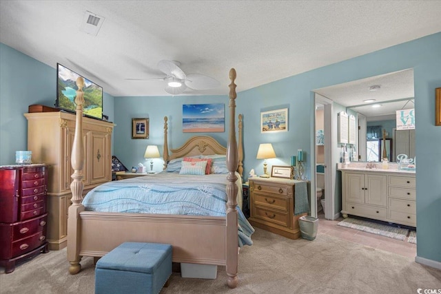 bedroom with carpet, a textured ceiling, ceiling fan, and a sink