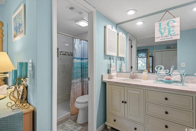full bathroom featuring vanity, toilet, visible vents, and a tile shower