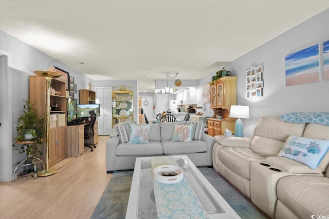 living area with light wood-style flooring and a notable chandelier