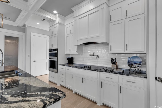 kitchen with coffered ceiling, double oven, black electric stovetop, and white cabinets