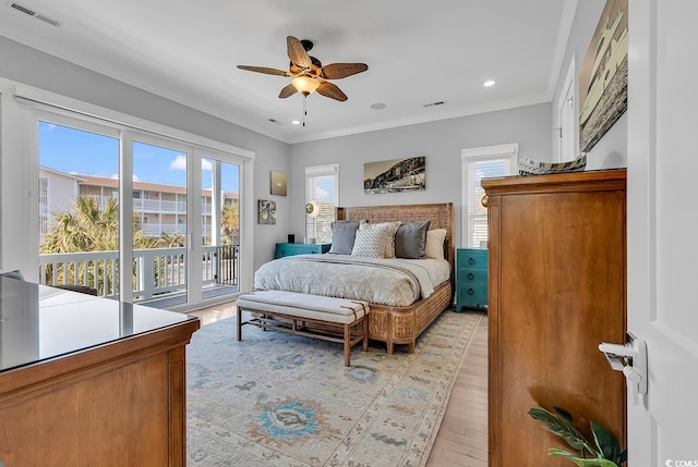 bedroom featuring light wood-type flooring, access to outside, visible vents, and ornamental molding