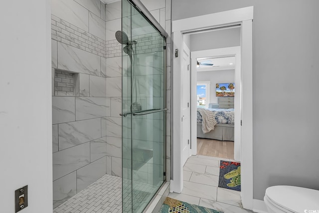 full bath with marble finish floor, connected bathroom, toilet, and a shower stall