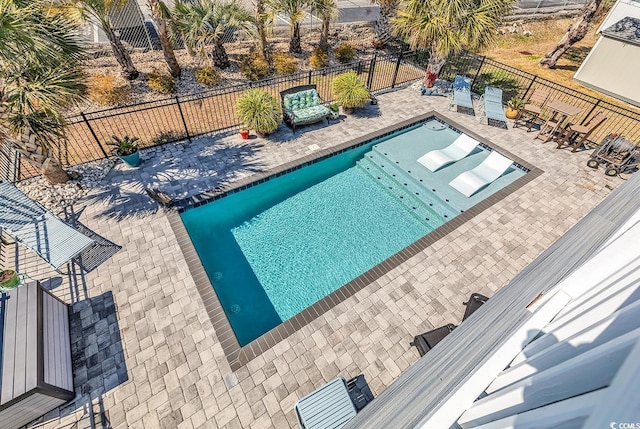 view of swimming pool featuring a fenced in pool, a fenced backyard, and a patio