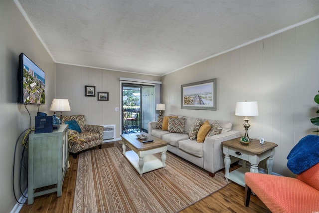 living room with a textured ceiling, wood finished floors, and crown molding