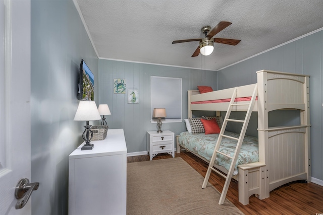 bedroom featuring a ceiling fan, crown molding, a textured ceiling, and wood finished floors