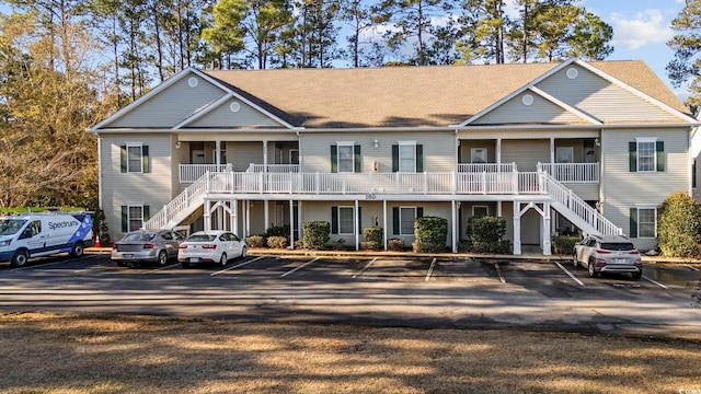 view of property with uncovered parking and stairway