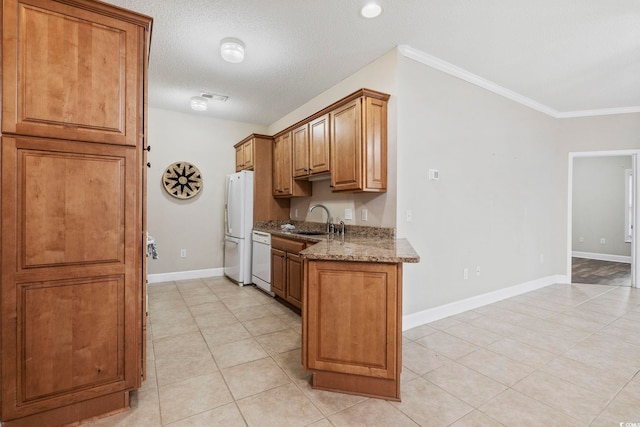 kitchen featuring visible vents, brown cabinetry, a sink, light stone countertops, and white appliances