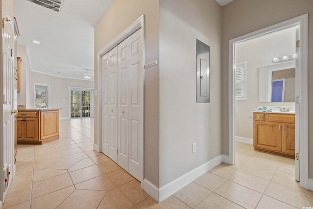 hallway featuring electric panel, visible vents, baseboards, and light tile patterned flooring