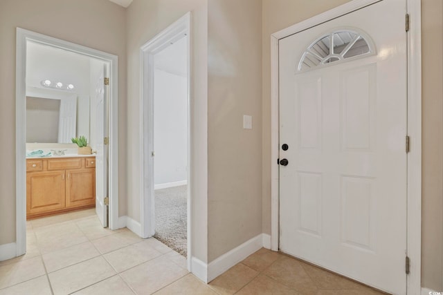 entryway with light tile patterned floors and baseboards