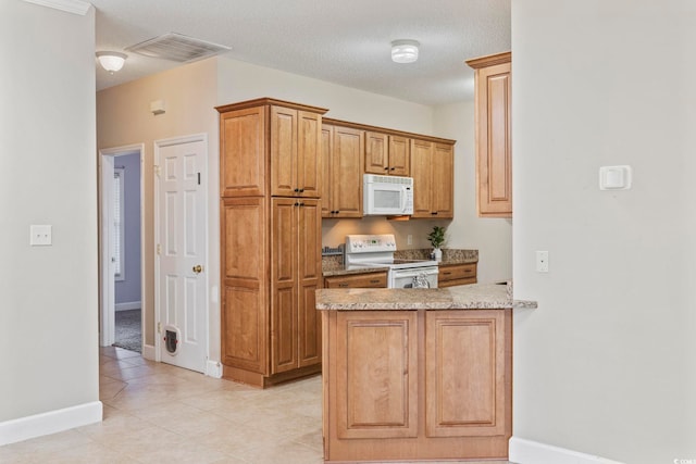 kitchen featuring a textured ceiling, light stone counters, a peninsula, white appliances, and visible vents