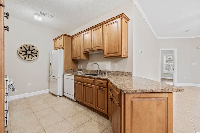 kitchen featuring visible vents, ornamental molding, a sink, light stone countertops, and white appliances