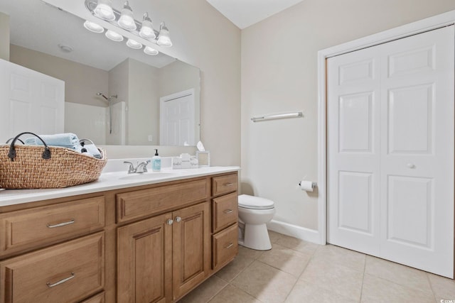 full bath featuring tile patterned flooring, toilet, vanity, baseboards, and a shower