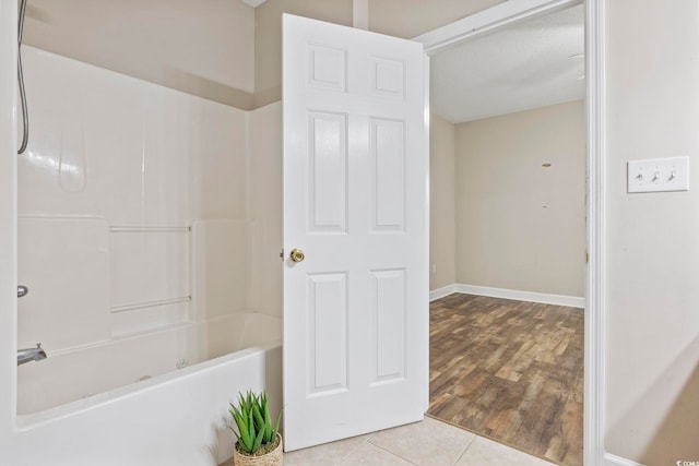 full bathroom featuring shower / tub combination, baseboards, and tile patterned floors