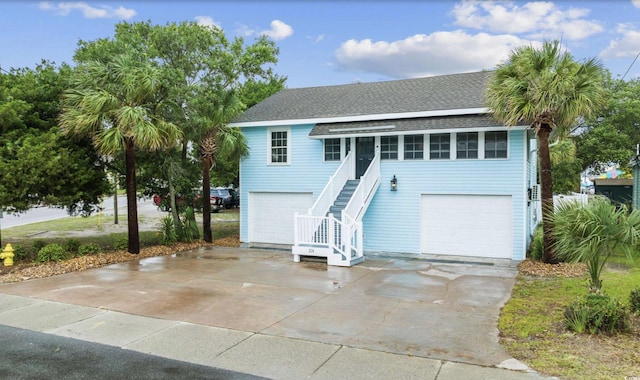 214 2nd Ave S, North Myrtle Beach, SC 29582 - view of front of house with stairway, roof with shingles, driveway, and an attached garage
