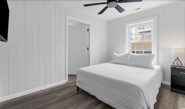 214 2nd Ave S, North Myrtle Beach, SC 29582 - bedroom featuring dark wood-style floors, ceiling fan, and wooden walls