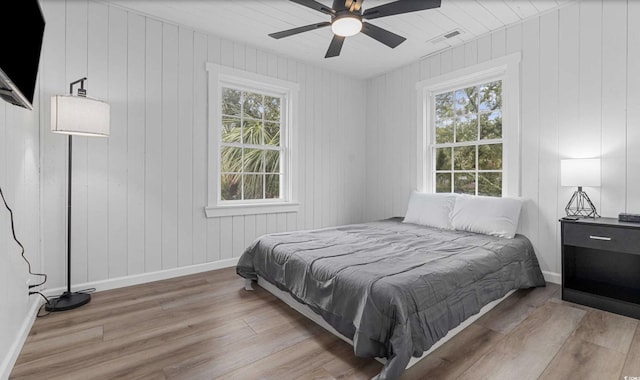 214 2nd Ave S, North Myrtle Beach, SC 29582 - bedroom with wood finished floors, multiple windows, ceiling fan, and wood walls