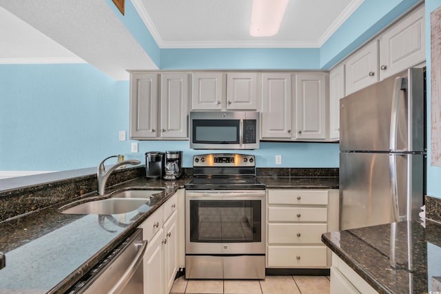9400 Shore Dr Unit 722, Myrtle Beach, SC 29572 - kitchen featuring appliances with stainless steel finishes, ornamental molding, dark stone countertops, white cabinetry, and light tile patterned flooring